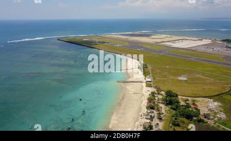 Luftaufnahme der Start- und Landebahn von der Spitze der Turm des internationalen Flughafens steuert Bali mit einem geparkten Flugzeug und mehrere Ebenen befinden sich auf dem Stockfoto