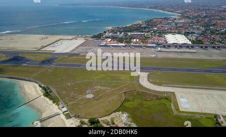 Luftaufnahme der Start- und Landebahn von der Spitze der Turm des internationalen Flughafens steuert Bali mit einem geparkten Flugzeug und mehrere Ebenen befinden sich auf dem Stockfoto