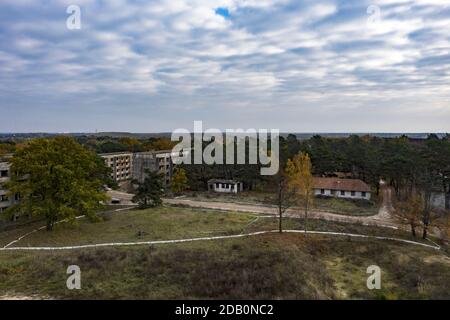 Elstal, Deutschland. November 2020. Blick auf die Ruinen des ehemaligen Olympischen Dorfes in Elstal in Brandenburg. Nach Jahrzehnten der Vernachlässigung mit dem damit einhergehenden Verfall der historischen Gebäude bestimmen Bauarbeiter die Ereignisse auf einem Teil des Areals. Sie haben den ehemaligen Speisesaal der Nationen im Olympischen Dorf umfassend renoviert und weitere neue Wohngebäude in unmittelbarer Nähe errichtet. (Aufnahme mit Drohne) Quelle: Paul Zinken/dpa-Zentralbild/ZB/dpa/Alamy Live News Stockfoto