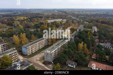 Elstal, Deutschland. November 2020. Blick auf die Ruinen des ehemaligen Olympischen Dorfes in Elstal in Brandenburg. Nach Jahrzehnten der Vernachlässigung mit dem damit einhergehenden Verfall der historischen Gebäude bestimmen Bauarbeiter die Ereignisse auf einem Teil des Areals. Sie haben den ehemaligen Speisesaal der Nationen im Olympischen Dorf umfassend renoviert und weitere neue Wohngebäude in unmittelbarer Nähe errichtet. (Aufnahme mit Drohne) Quelle: Paul Zinken/dpa-Zentralbild/ZB/dpa/Alamy Live News Stockfoto