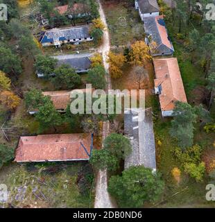 Elstal, Deutschland. November 2020. Blick auf die Ruinen des ehemaligen Olympischen Dorfes in Elstal in Brandenburg. Nach Jahrzehnten der Vernachlässigung mit dem damit einhergehenden Verfall der historischen Gebäude bestimmen Bauarbeiter die Ereignisse auf einem Teil des Areals. Sie haben den ehemaligen Speisesaal der Nationen im Olympischen Dorf umfassend renoviert und weitere neue Wohngebäude in unmittelbarer Nähe errichtet. (Aufnahme mit Drohne) Quelle: Paul Zinken/dpa-Zentralbild/ZB/dpa/Alamy Live News Stockfoto