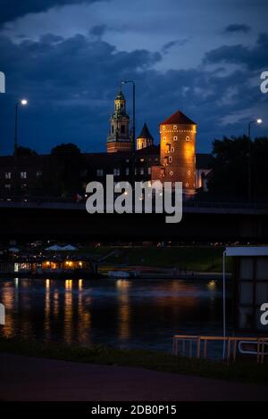 Boot auf dem Wasser unter der Brücke neben dem Wawel Schloss in Krakau, Polen an einem Sommerabend. Stockfoto