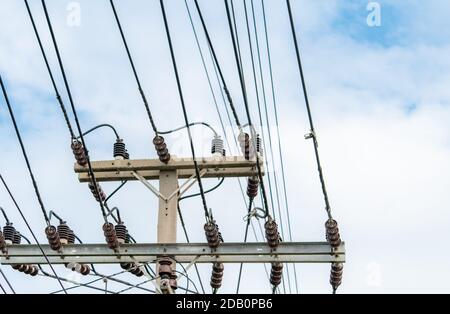 Dreiphasige Stromversorgung für die Übertragung von Strom durch Stromnetze. Elektrische Energie für die Unterstützung der Fertigungsindustrie. Hochspannungs-elektrische Pole und Stockfoto