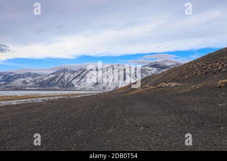 LEE VINING, CALIFORNIA, USA - Nov 14, 2020: Ein schwarzer Sandhügel in der Nähe von Black Point am Mono Lake steht mit den Bergen der Sierra Nevada i Stockfoto