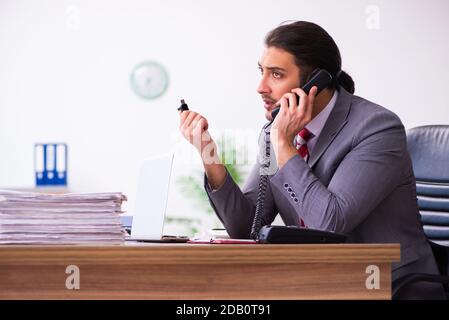 Männlicher Mitarbeiter, der Flash-Laufwerk in den Laptop einsteckt Stockfoto