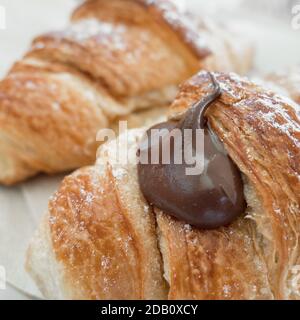 Hausgemachte Schokoladencroissants. Frische italienische Croissants gefüllt mit Schokoladencreme. Nahaufnahme. Stockfoto