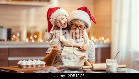 Frohe Weihnachten und frohe Feiertage. Familienzubereitung Urlaub Essen. Oma und Enkelin kochen Plätzchen. Stockfoto