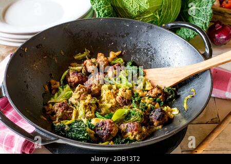 Gebratene Fleischbällchen mit wirsing in einer Wok-Pfanne Stockfoto