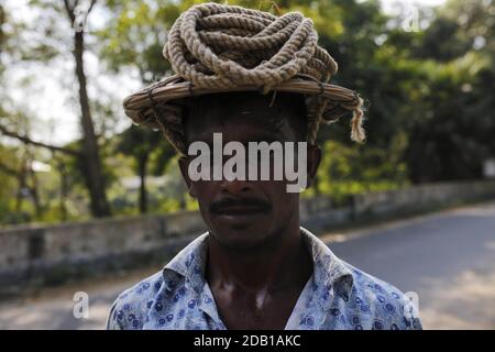 16. November 2020, Dhaka, Bangladesch: Ein Arbeiter posiert für ein Foto, während er von einem Feld am Stadtrand von Dhamoirhat, Naogaon, geerntetes Reisig trägt. (Bild: © MD Mehedi Hasan/ZUMA Wire) Stockfoto