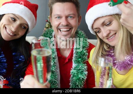 Mann und zwei Frauen feiern Neujahr und Weihnachten Stockfoto