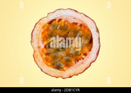 Maracuja in der Hälfte und ganz mit Blatt auf gelbem Hintergrund geschnitten. Passionsfrucht gelb mit Fruchtsaft und Samen Stockfoto