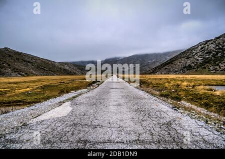 Eine lange gerade Straße, die in der Ferne zu einem Berg führt. Stockfoto