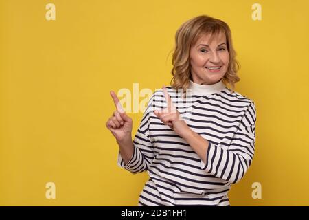 Reife kaukasische Frau mit Finger Punkt Aisde. Stockfoto