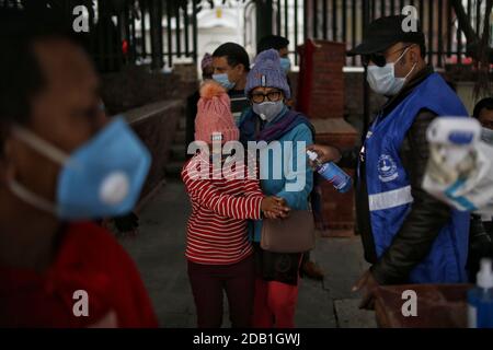 Kathmandu, Nepal. November 2020. Menschen mit Gesichtsmasken haben ihre Hände desinfiziert und die Temperatur überprüft, wenn sie Rani Pokhari (Königinnenteich) während Bhai Tika, dem letzten Tag des Tihar Festivals in Kathmandu, Nepal, am 16. November 2020 betreten. Quelle: Sulav Shrestha/Xinhua/Alamy Live News Stockfoto