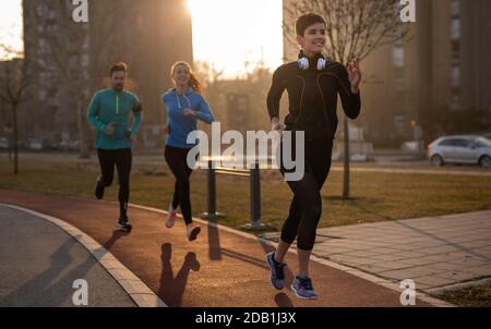 Joggen und Laufen sind Fitness-Erholungen. Glückliche Gruppe von Freunden trainieren zusammen. Stockfoto
