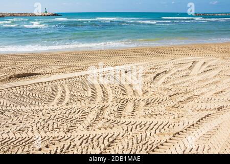 Viele durchteuften Fahrzeugspuren auf Strandsand. Tel Aviv, Israel. Stockfoto