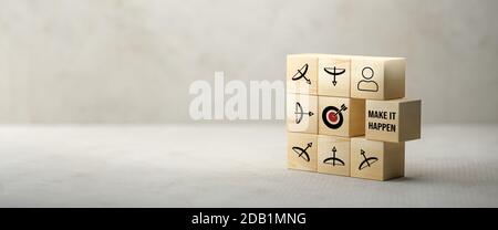 Würfel mit Pfeil- und Bogensymbolen, die alle in den zeigen Mitte zu einem Zielsymbol und einer Meldung MACHEN ES MÖGLICH Auf Papieroberfläche vor Betonrückseite Stockfoto