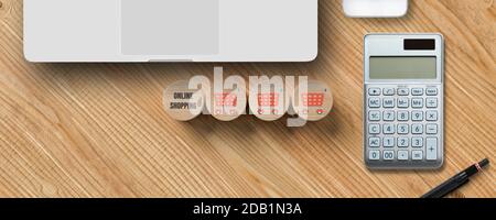 Würfel mit Shopping-Ikonen, ein Laptop und ein Rechner auf Holzhintergrund Stockfoto