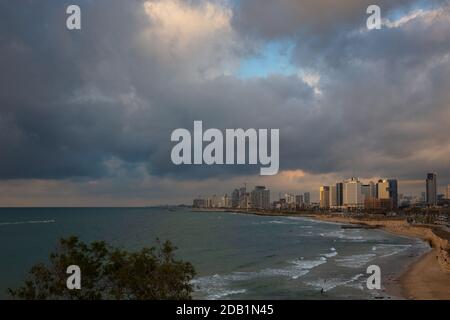 TEL AVIV, ISRAEL - 7. MÄRZ 2019: Tel Aviv Strand und Innenstadt vor einem Regensturm. Moderne Wolkenkratzer, Bürogebäude, Hotels in dramatischer Beleuchtung. Stockfoto