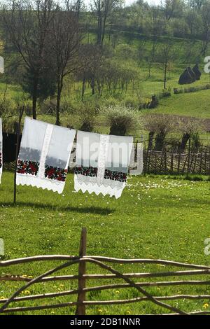 Maramures, Rumänien. Schöne handgenähte Bettwäsche trocknen auf einer Wäscheleine. Stockfoto