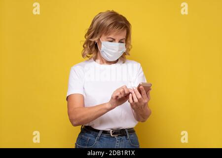 Frau hat Grippe, trägt schützende medizinische Maske, um andere Menschen nicht zu infizieren, Surfen Interne Stockfoto