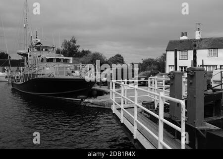 Pensionierte Rettungsboot vertäut in Heybridge Essex UK mit historischen Gebäuden Im Hintergrund in schwarz und weiß Stockfoto