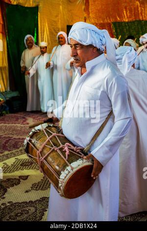 Männer in traditioneller Kleidung spielen das lokale Instrument während einer traditionellen Hochzeitszeremonie in bandar-e kong, in der iranischen Provinz Hormozgan. Stockfoto
