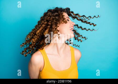 Foto von überglücklich Dame warme Brise Schlag Gesicht Frisur Flug Tragen Sie einen isolierten blauen Hintergrund Stockfoto