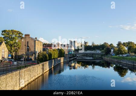 Kilkenny Castle unter einem sonnigen klaren blauen Himmel, der sich im Fluss Nore, County Kilkenny, Irland, widerspiegelt Stockfoto