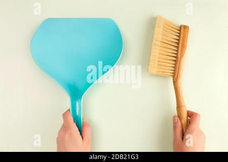 Staubwanne und Bürste in den Händen der Frau. Reinigungskonzept. Stockfoto