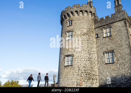 Besucher kommen an einer Statue vor dem Schloss auf dem Gelände von Kilkenny Castle, County Kilkenny, Irland vorbei Stockfoto