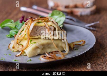 Schwäbische maultasche mit Zwiebeln auf einer Platte Stockfoto