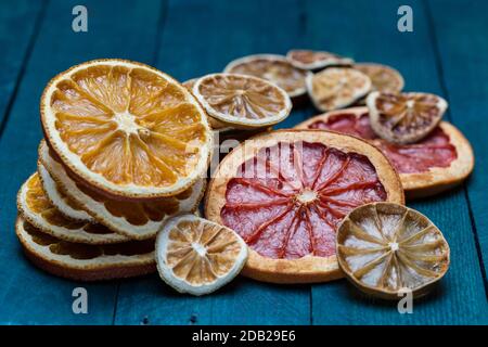 Getrocknete Orangen, Zitrone, Limette und Grapefruit auf benzinfarbenem Holz. Stockfoto