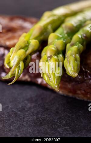 Grüner Spargel auf einem Steak Stockfoto