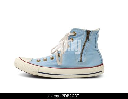 Getragen wird der hellblaue Sneaker mit gefesselten weißen Schnürsenkeln und einem eisernen Reißverschluss, der auf weißem Hintergrund isoliert ist, Schuhe stehen seitlich Stockfoto