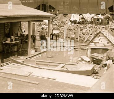 Kanus gibt es im Überfluss als Flutwasser das Ufer unter Betonbrücke und neben Eisenbahnhopper Autos.. Stockfoto