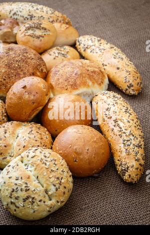 Verschiedene Arten von Vollkorn Brot und Brötchen auf braunem Hintergrund Stockfoto