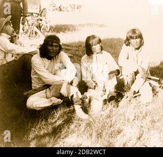 Thrasher und drei Indianer sitzen draußen. Stockfoto