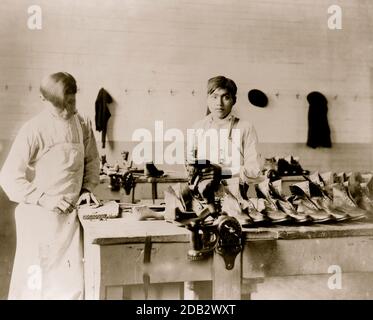 Zwei Jungen, die Schuhe an der Carlisle Indian School machen oder reparieren]. Stockfoto