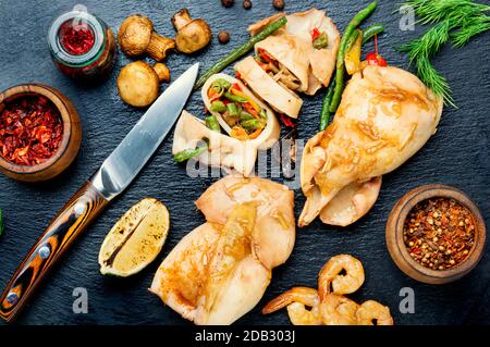 In Scheiben gebackene Tintenfisch mit Gemüse auf einem Schieferbrett.Squid gefüllt mit Pilzen.Bbq Kalamärstein Stockfoto