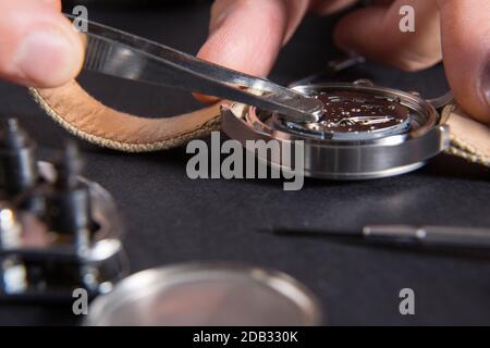 Der Austausch einer Uhrenbatterie mit uhrmacher Tools Stockfoto