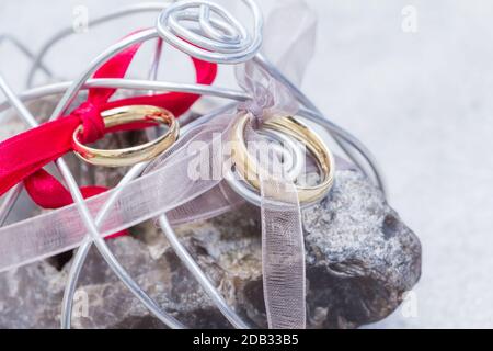 Feier Symbol für Zweisamkeit, Einheit, Liebe. Schöner Ring für Braut und Bräutigam warten auf Gelübde auf Dekoration Stein in Riemen. Stockfoto