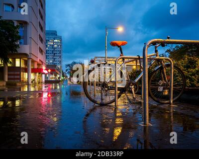Ein Fahrrad links auf Nacht regnerischen Stadt Straße Stockfoto