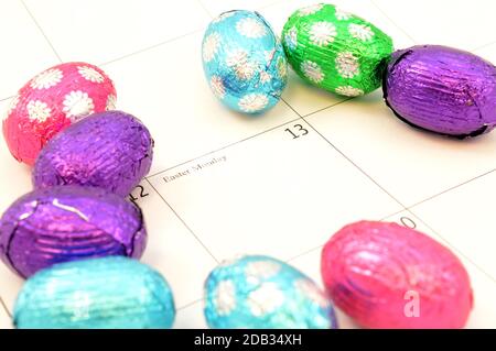 Nahaufnahme des Ostermontags markiert auf dem Kalender mit einigen Schokoladeneiern. Stockfoto