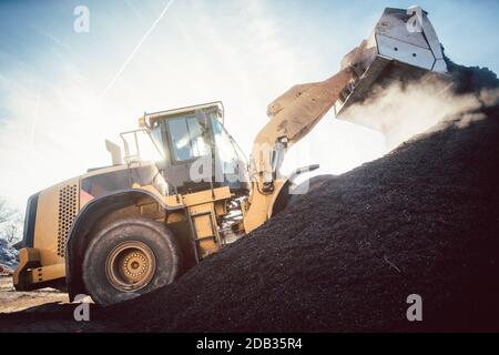 Bulldozer, der Biomasse auf Haufen für Kompostierung in Industrieanlagen legt Stockfoto