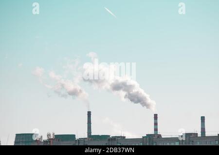 Kopieren Raum mit industriellen Kaminen mit Rauch auf blauem Himmel Hintergrund. Smokestack Verschmutzung in der Luft als Umweltproblem Stockfoto