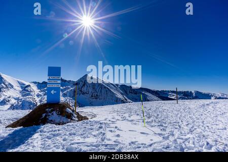 Sign on ski slopes with directions to villages, Pas de la Casa, Grau Roig and Funicamp. Beautiful mountain range covered in snow, Pyrenees, Andorra Stockfoto