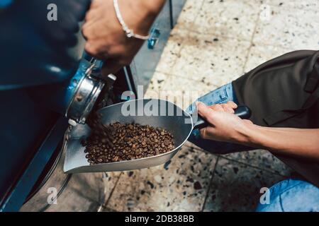 Frau nimmt Kaffeebohnen aus dem Lager, um sie zu verkaufen Stockfoto