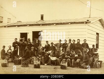 Drum Corps of 10th Veteran Reserve Corps, Washington, D.C., April, 1865; Gruppenportrait von etwa 30 Männern, einige mit Instrumenten und andere Lesen, Schreiben und Spielkarten.. Stockfoto