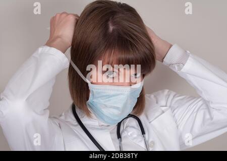 Femle Doctor legt eine Schutzmaske an Stockfoto